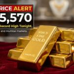 A digital gold rate ticker showing a sharp upward arrow next to "₹1,55,570" with a background of a jewelry store.