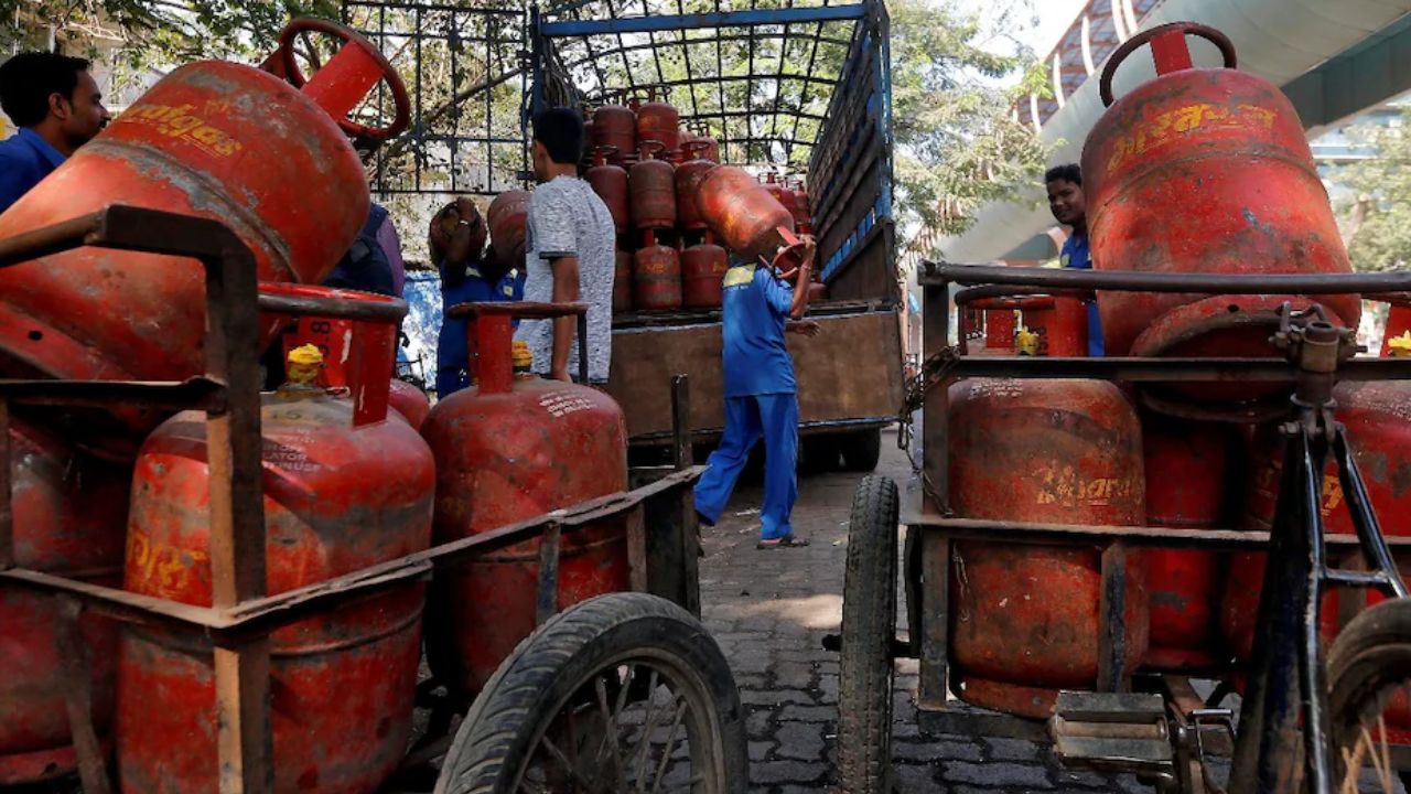 Red domestic and blue commercial LPG gas cylinders with price drop alert tag in India